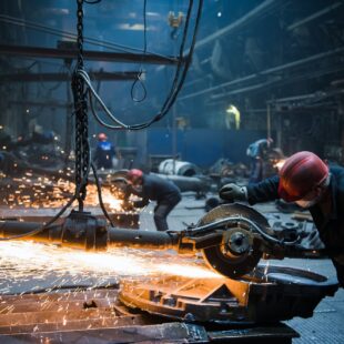 Welder used grinding stone on steel in factory with sparks